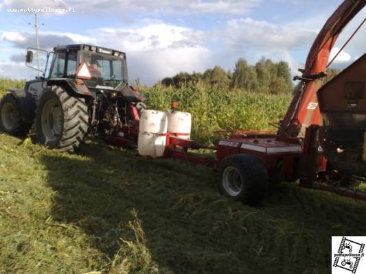 Ja perään tarkkuussilppurilla...
Toinen epäilyksen aihe mutta turhaan, eihän tässä mitään erikoistyökoneita tarvitse.
Traktorina on Valmet 6900 Finlandia, silppuri JF 1100 ja perässä venäläinen itsepurkava ruokintavaunu että saa suoraan elukoille sapuskaa. :)
Vähän kyllä peltoon jättää tähkiä ja korsia...
